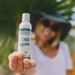 Shallow Focus Photo of Woman Holding CBD Lotion Bottle