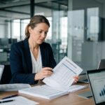 Directrice financière analysant des devis fournisseurs dans une salle de conférence moderne en 2026